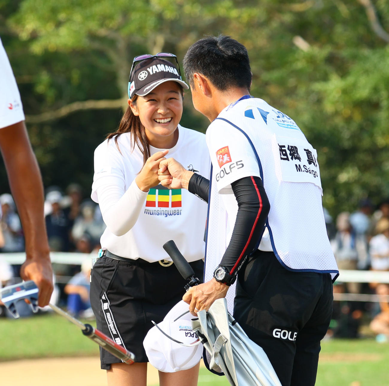 18番　優勝が決まり笑顔でキャディーとグータッチを交わす神谷（撮影・冨田成美）