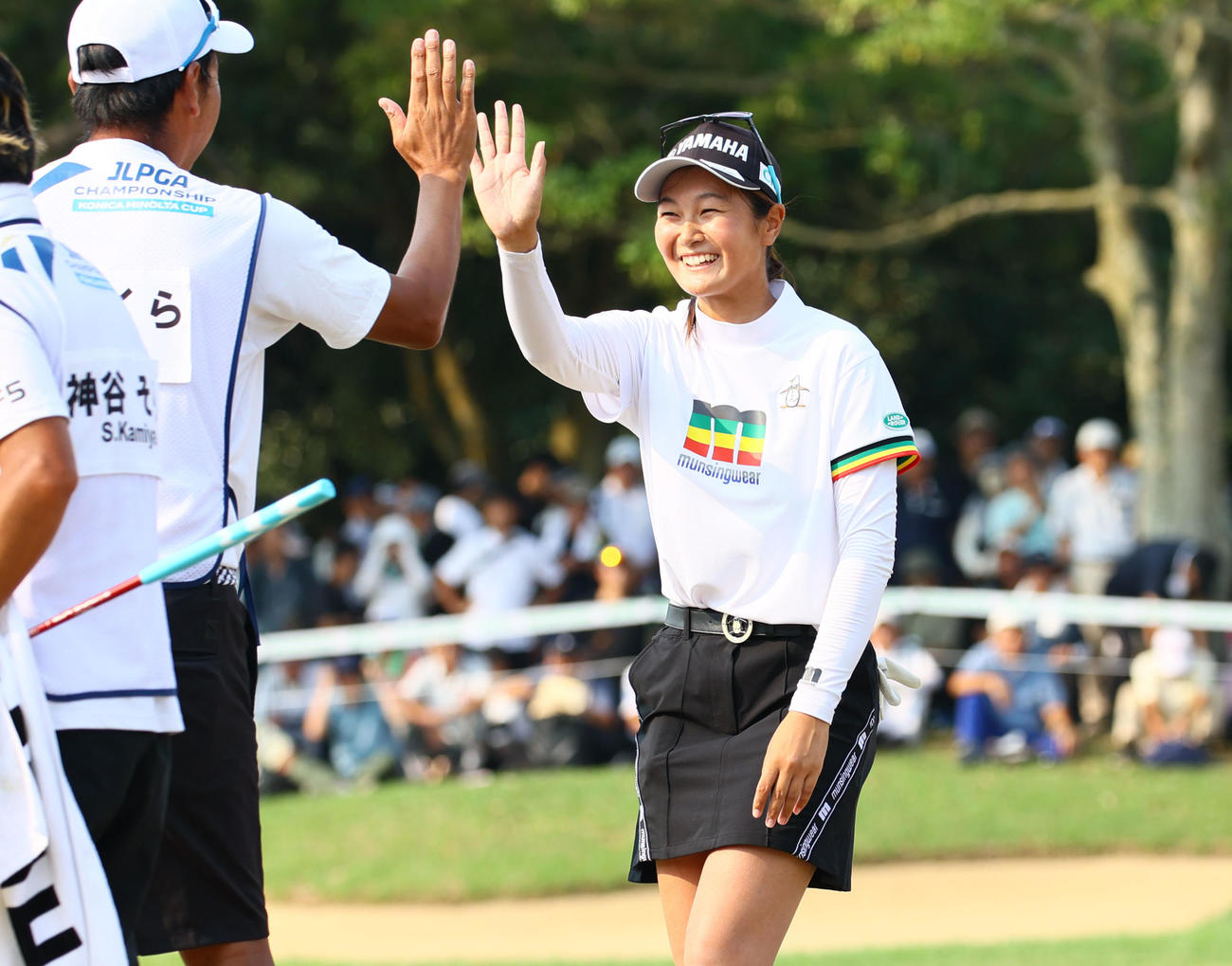 18番　優勝が決まり笑顔でキャディーとタッチを交わす神谷（撮影・冨田成美）