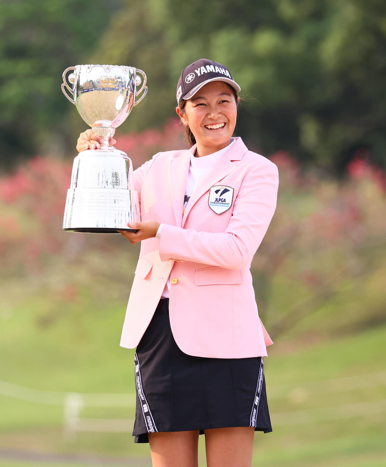 通算12アンダーで優勝し、カップを手に笑顔の神谷。国内4大大会初制覇を果たした（撮影・冨田成美）