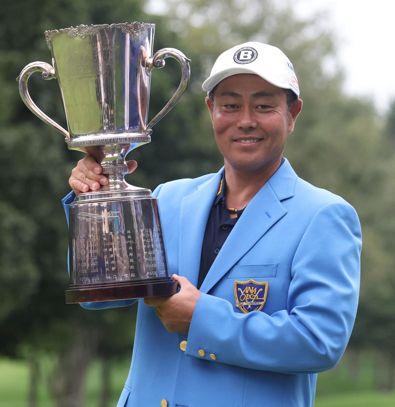 優勝杯を手に笑顔で記念撮影に応じる谷原（撮影・佐藤翔太）