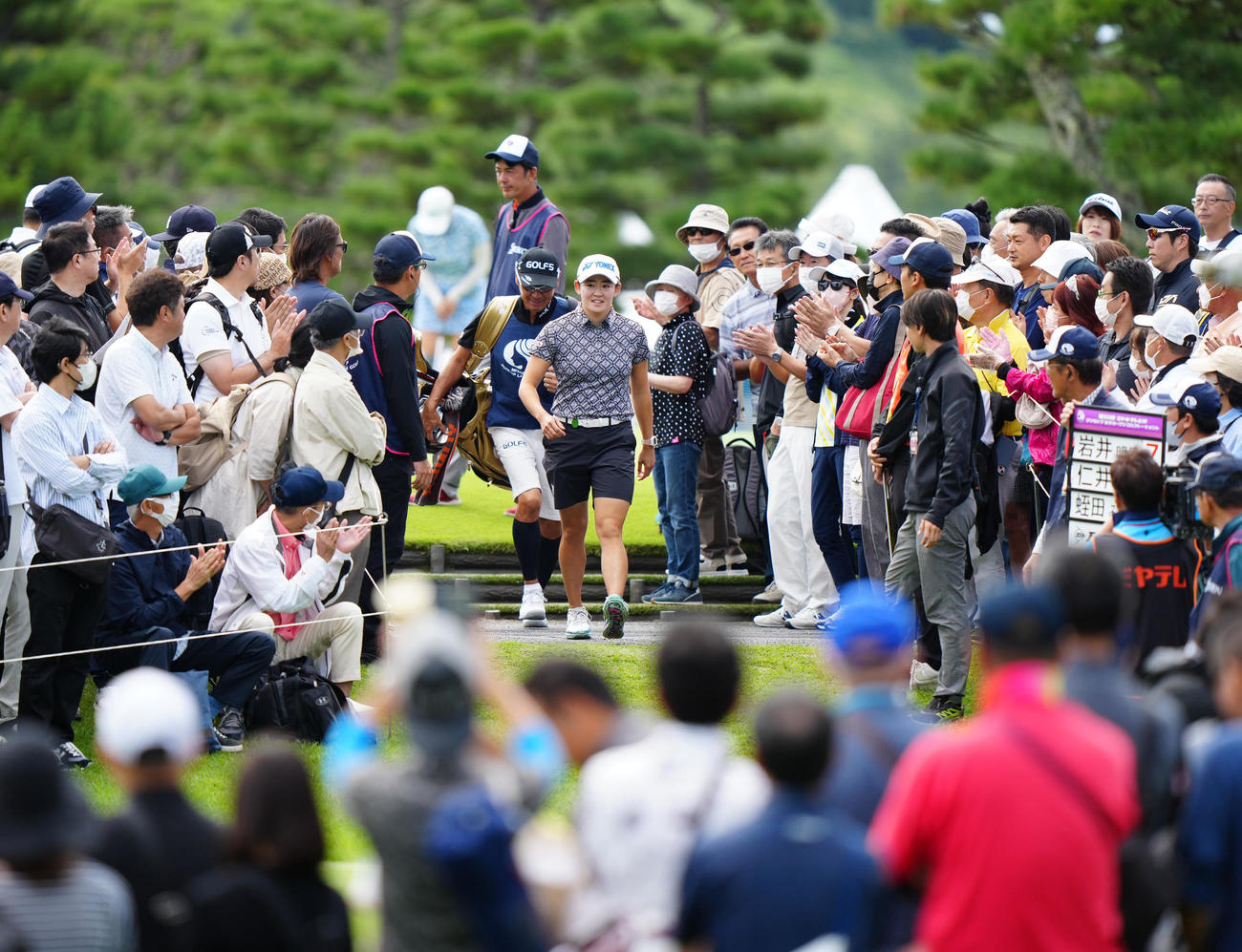 大勢のギャラリーの拍手を受けながら、1番に向かう岩井明（中央）（撮影・江口和貴）