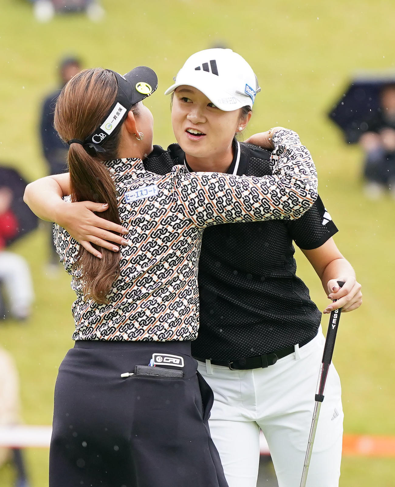 最終ホールでウイニングパットを決め、同組の吉本（手前）と抱き合い喜ぶ森田（撮影・狩俣裕三）