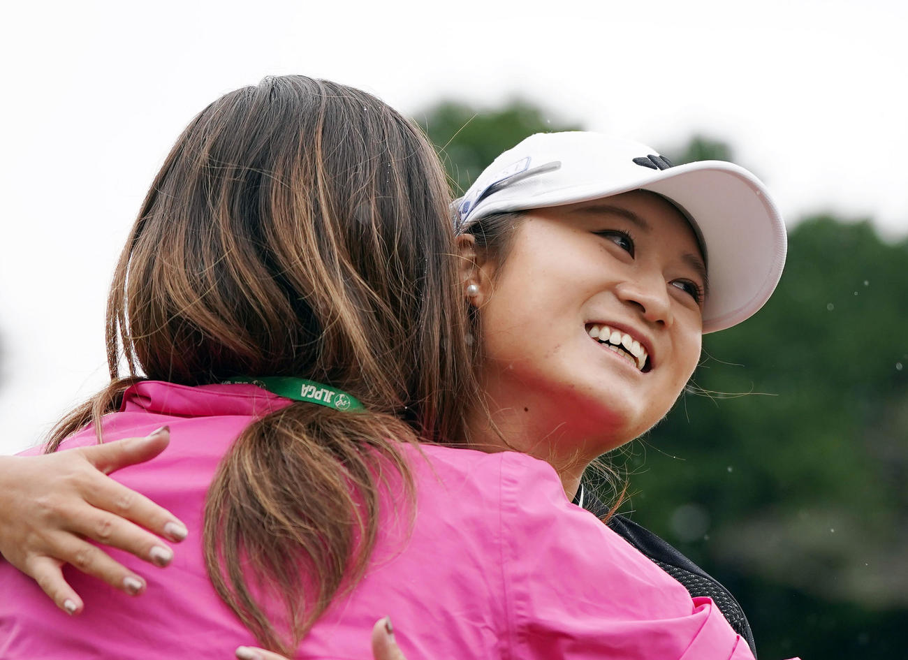 最終ホールでウイニングパットを決め、関係者と抱き合い喜ぶ森田（撮影・狩俣裕三）