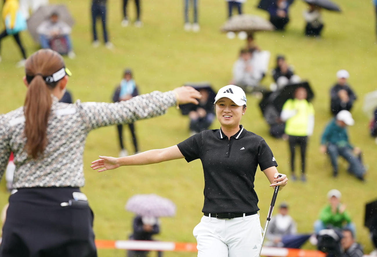 最終ホールでウイニングパットを決め、同組の吉本（手前）と喜び合う森田（撮影・狩俣裕三）