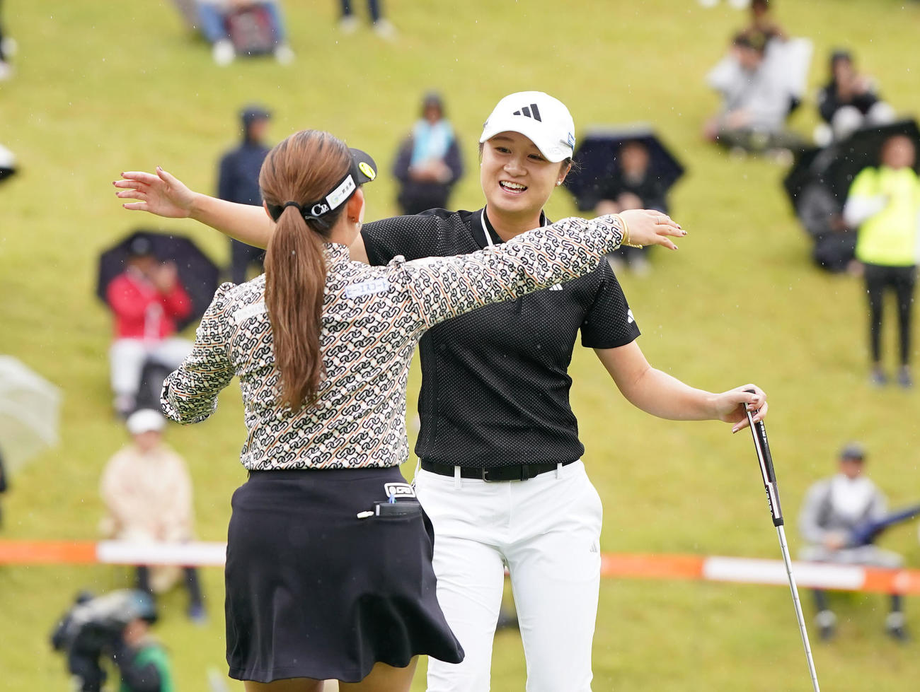 最終ホールでウイニングパットを決め、同組の吉本（手前）と抱き合い喜ぶ森田（撮影・狩俣裕三）