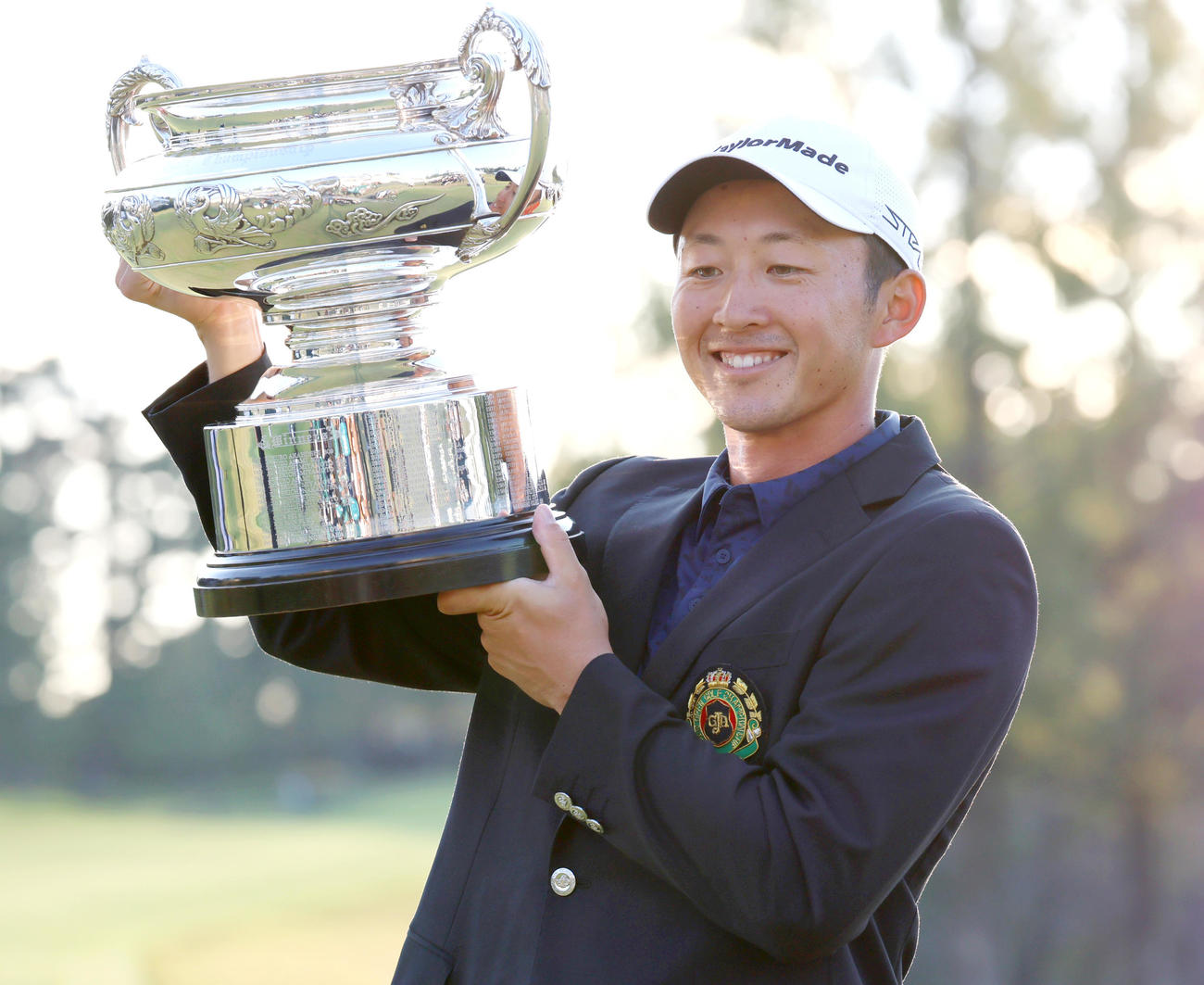 日本オープンゴルフ選手権を制した岩崎は優勝カップを手に笑顔を見せる（撮影・上山淳一）