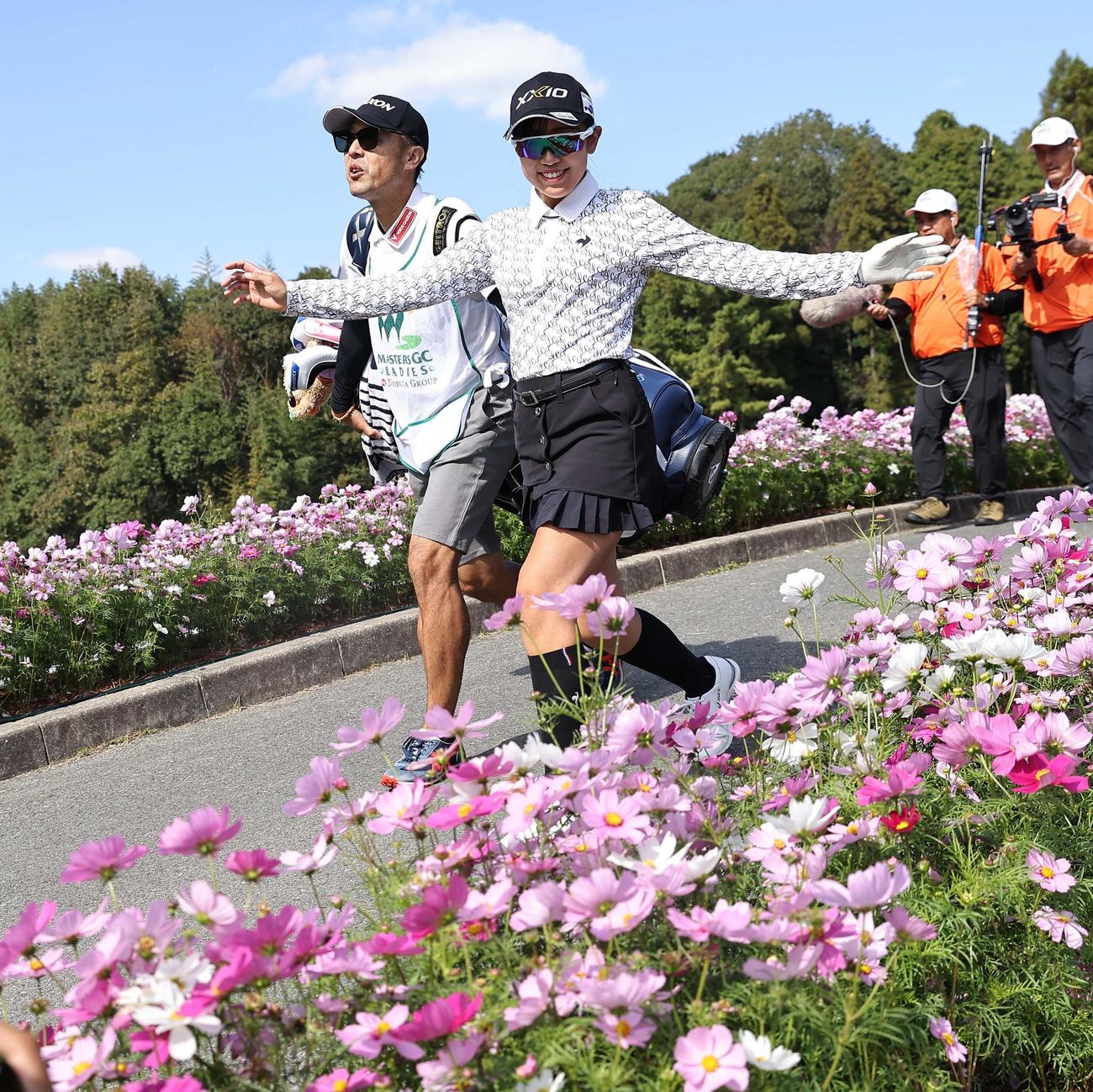 16番、コスモスを前に笑顔を見せる菅沼（撮影・上田博志）