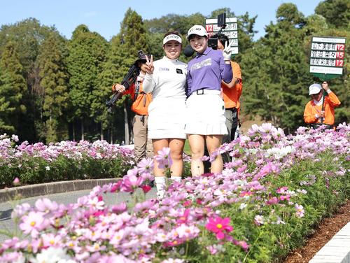 16番、コスモスを前に笑顔でピースサインを出す山下（左）と尾関（撮影・上田博志）