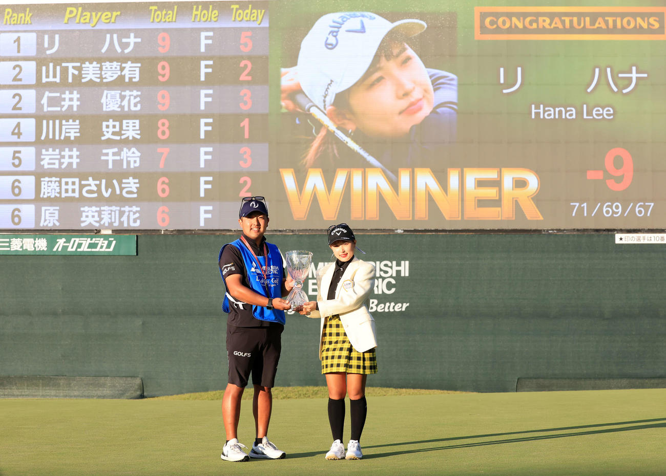 初優勝を決め、優勝杯を手にキャディーと記念撮影するリ・ハナ（撮影・浅見桂子）