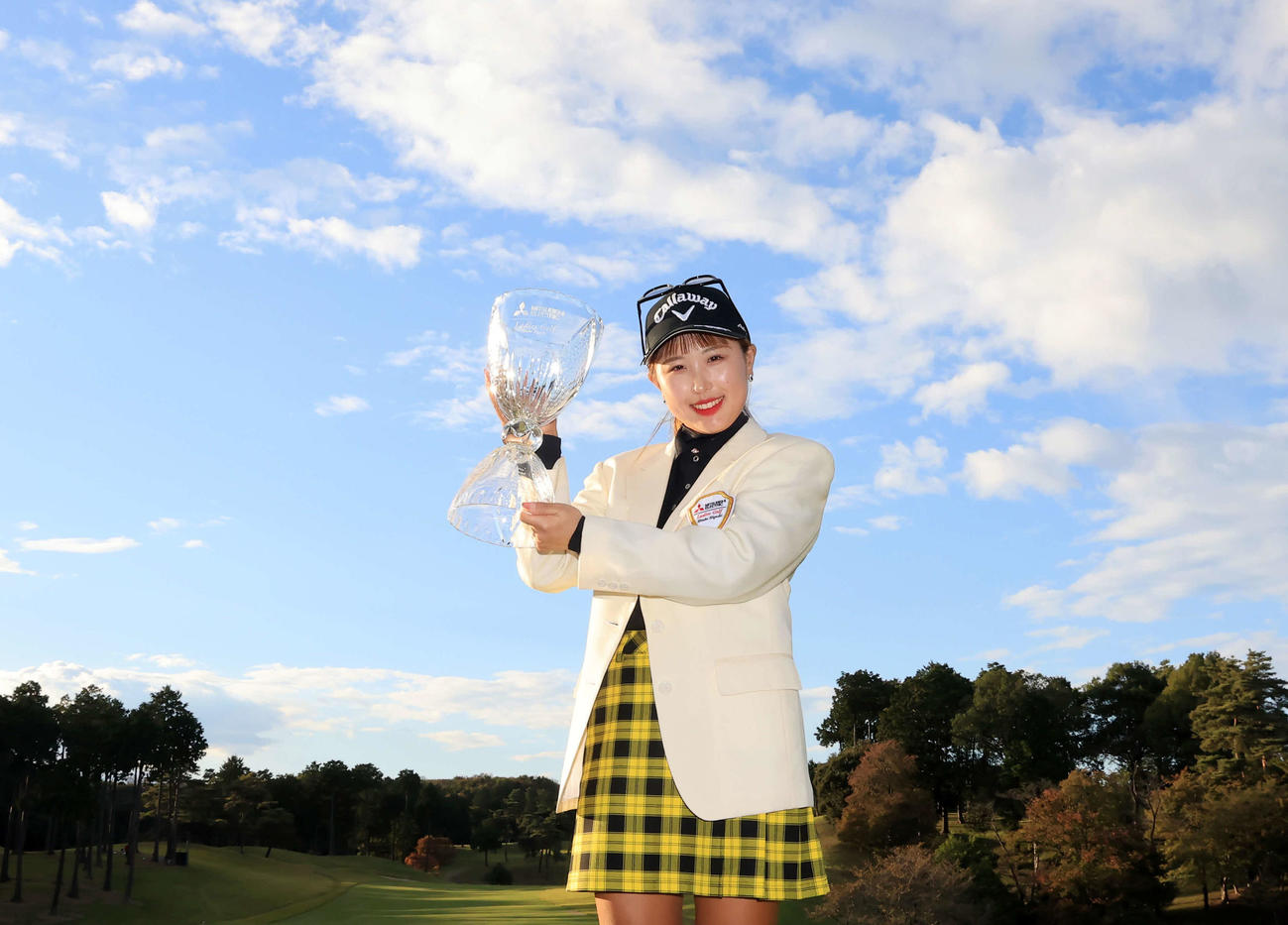 初優勝を決め、青空を背に優勝杯を手に笑顔を見せるリ・ハナ（撮影・浅見桂子）