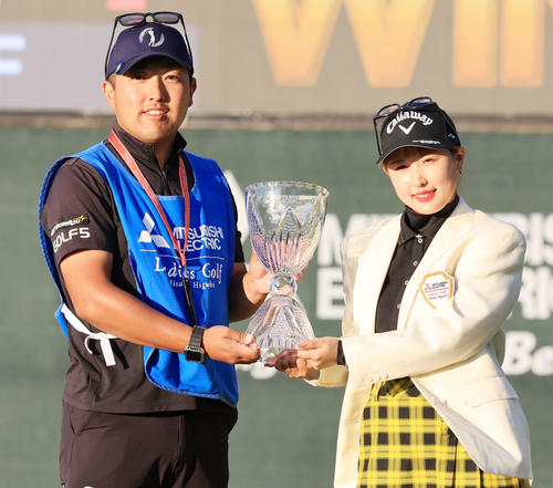 初優勝を決め、優勝杯を手にキャディーと記念撮影するリ・ハナ（撮影・浅見桂子）