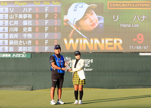 初優勝を決め、優勝杯を手にキャディーと記念撮影するリ・ハナ（撮影・浅見桂子）