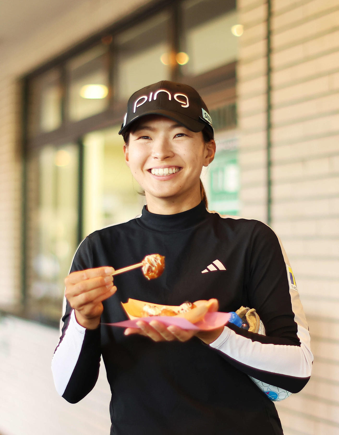 たこ焼きを手に笑顔を見せる渋野（撮影・河田真司）