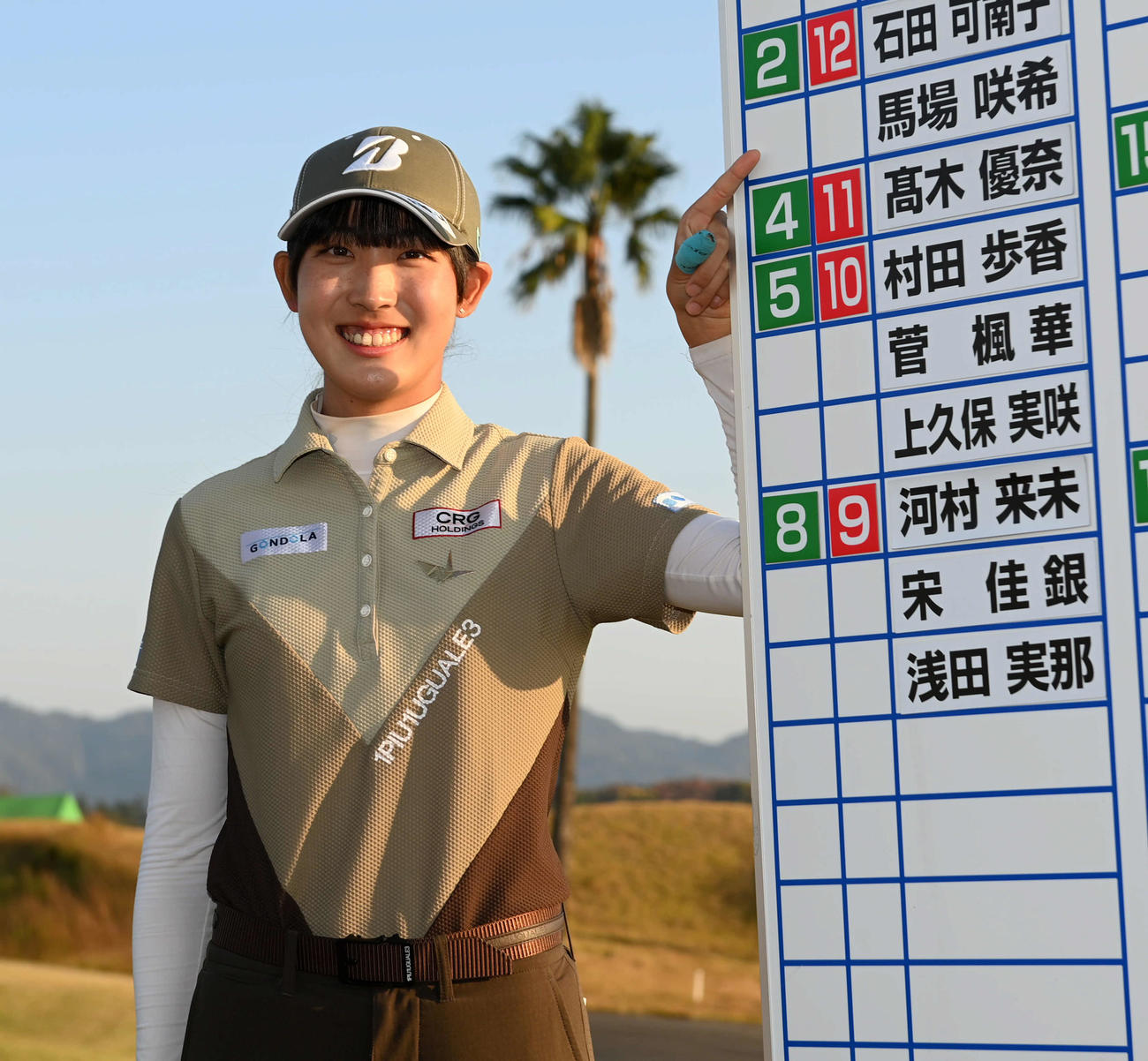 合格者ボードの名前を指さし笑顔を見せる馬場（撮影・前岡正明）
