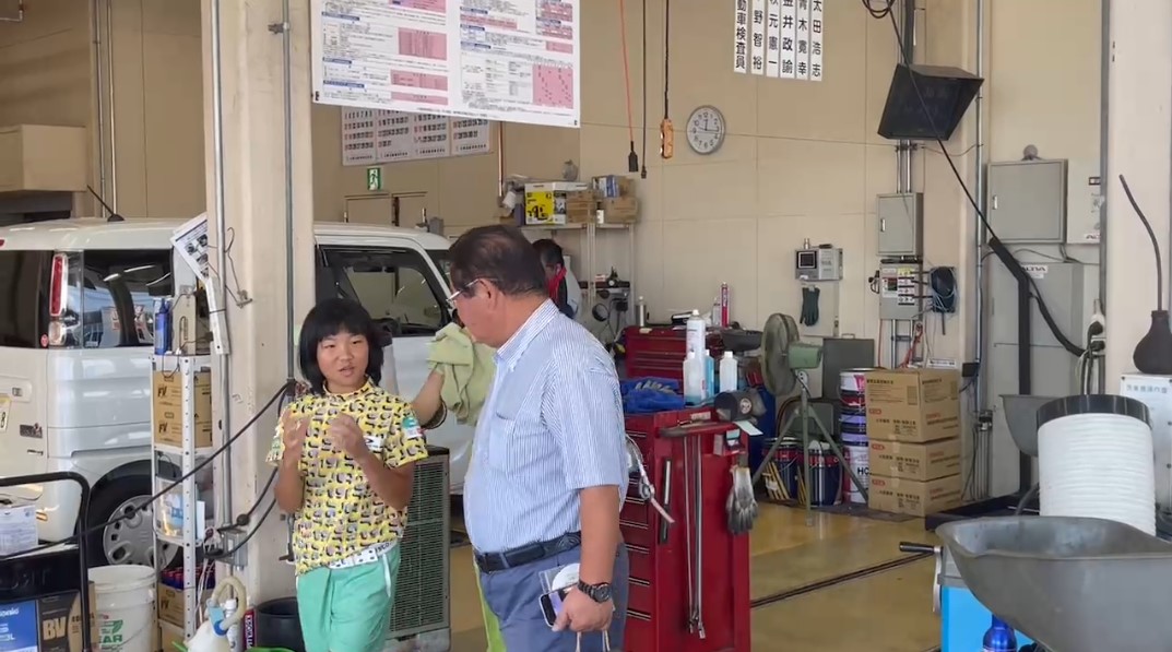 所属契約を結んだ太陽自動車で、松岡繁男会長から説明を受ける「天才ゴルフ少女」須藤弥勒（左）（本人提供）