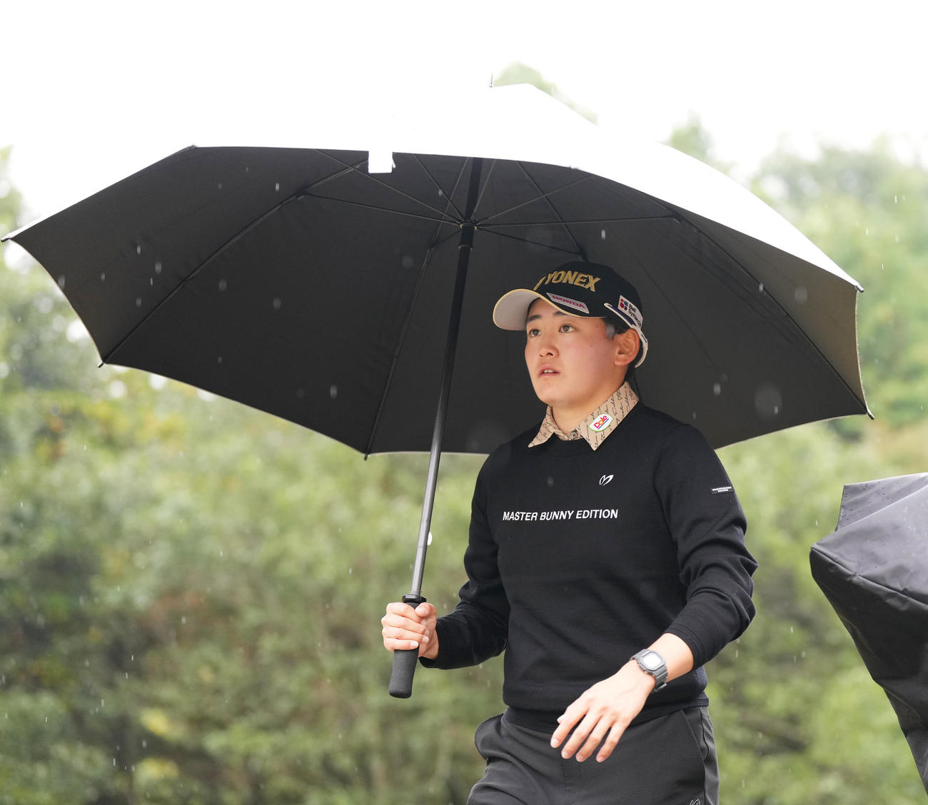 雨の中、傘をさしてラウンドする岩井明（撮影・菅敏）