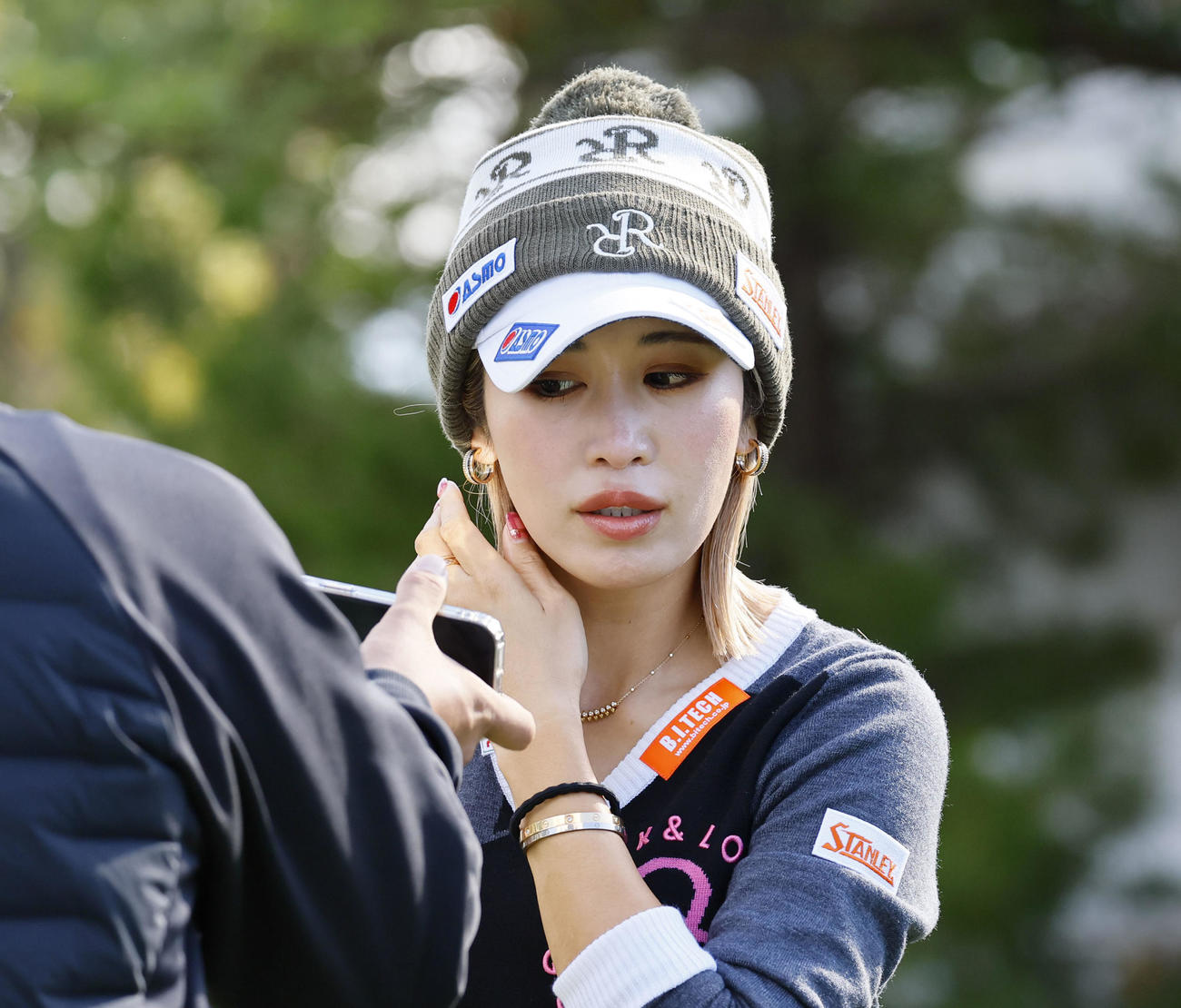 練習場で、写真撮影の前に髪を整える金田久美子（撮影・藤尾明華）