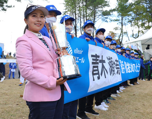 優勝、横断幕の横で笑顔を見せる青木瀬令奈（撮影・藤尾明華）