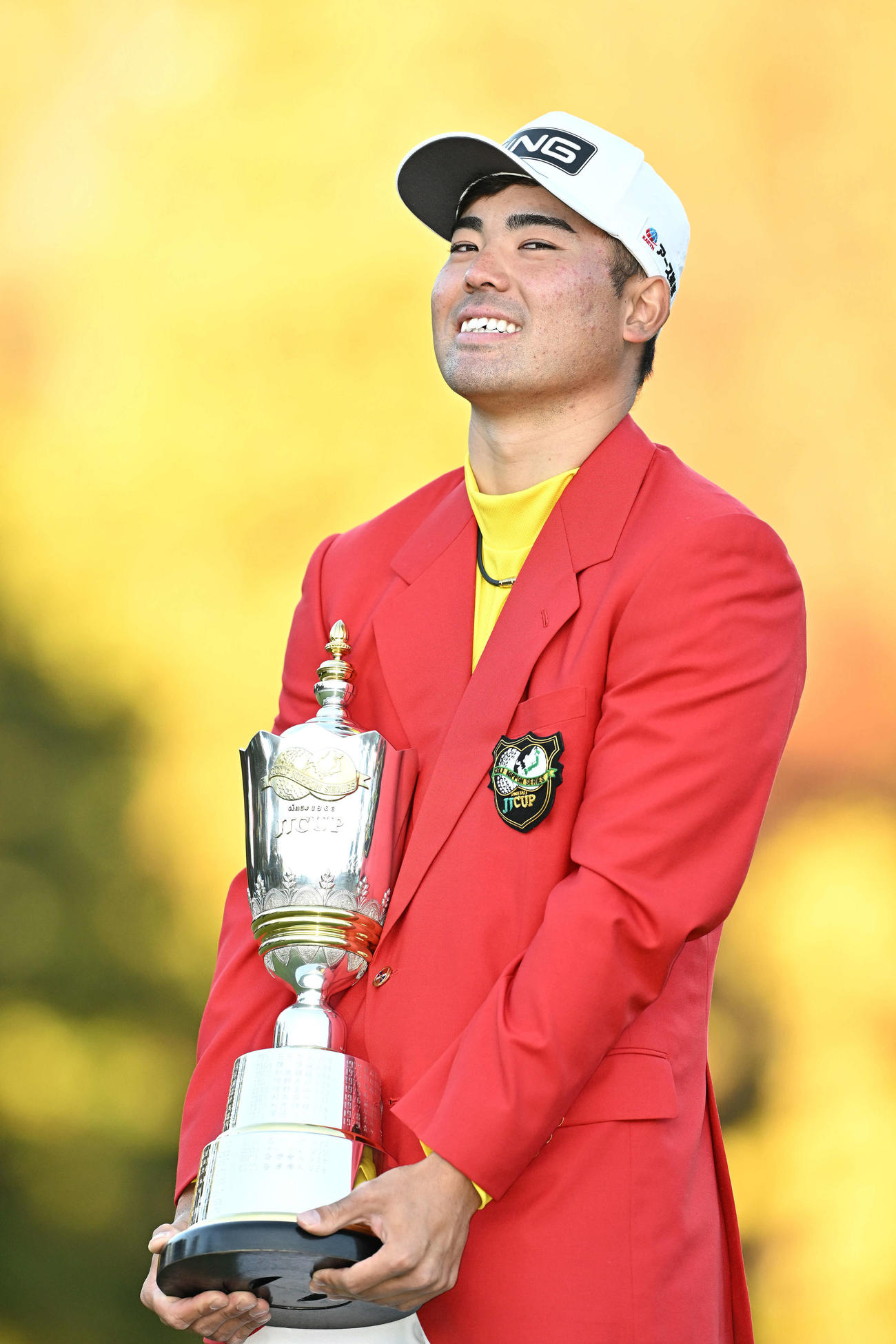 記念撮影する蝉川泰果は、優勝カップが重くて途中で休憩する（撮影・滝沢徹郎）