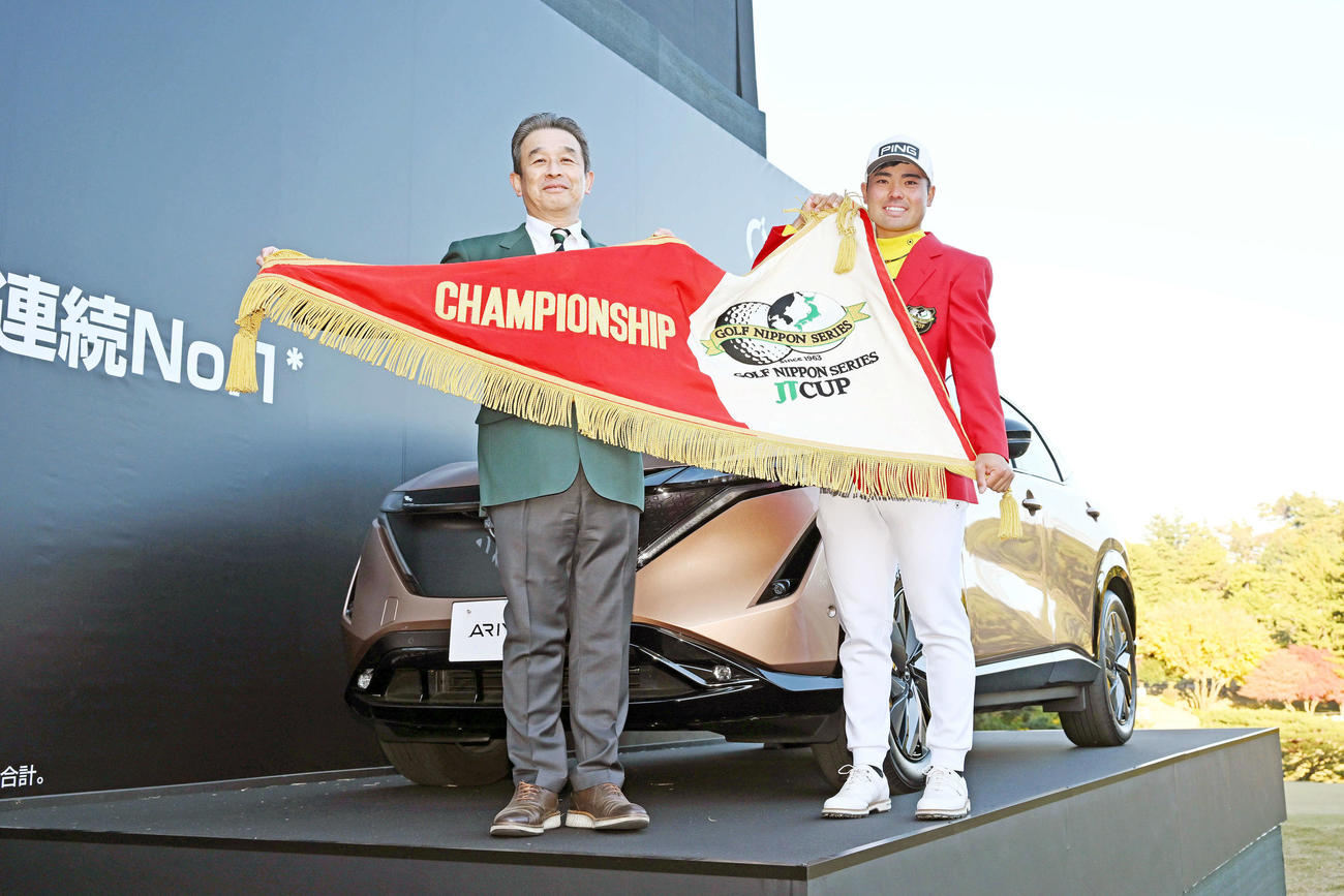 優勝した蝉川（右）は日産東京販売ホールディングス代表取締役社長の竹林彰氏と、日産「アリア」の前で大会ペナントを手に記念撮影する（撮影・滝沢徹郎）