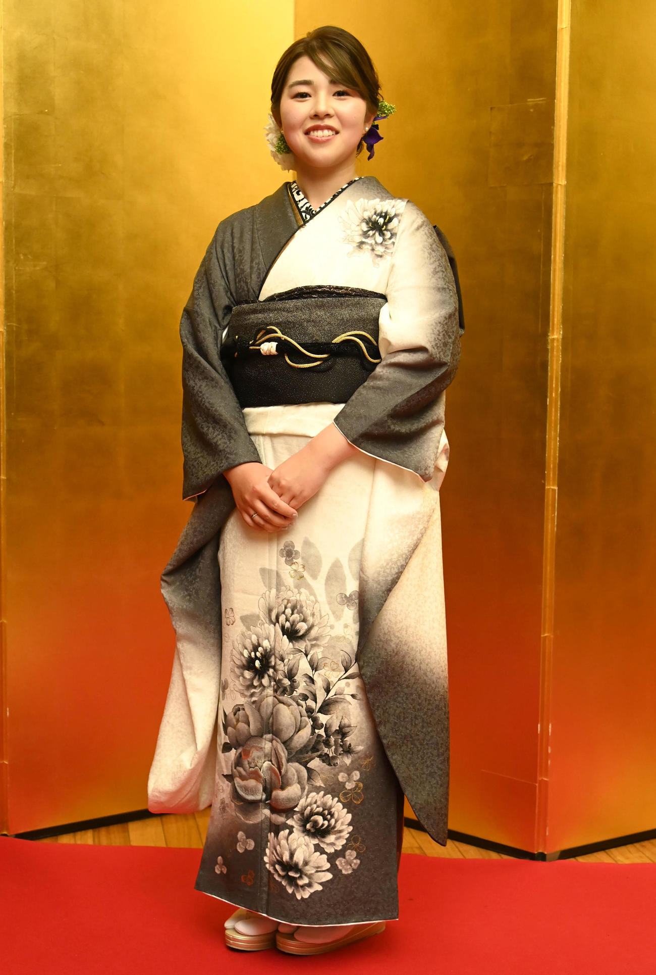 金屏風の前で記念撮影をする山下美夢有（撮影・石井愛子）