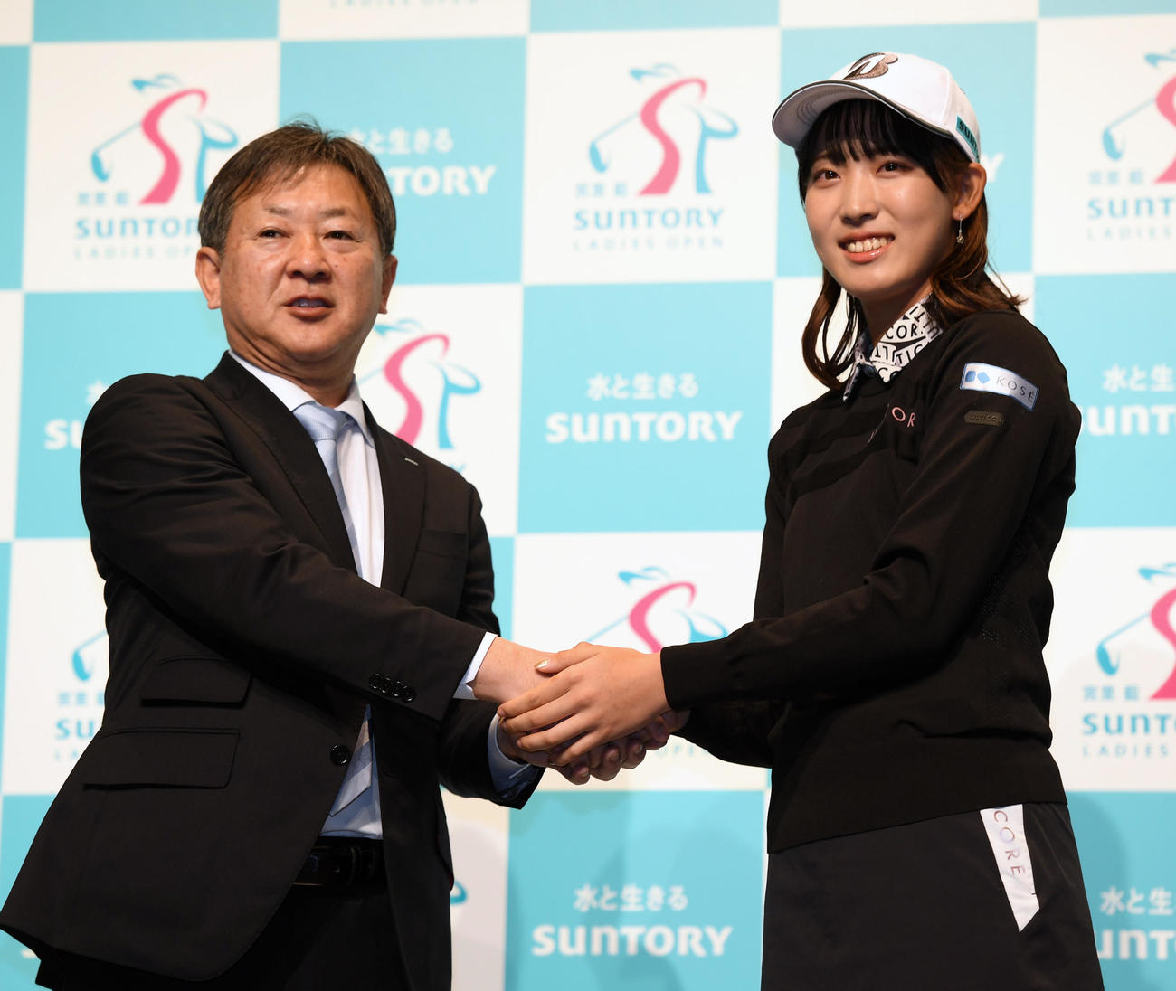 サントリーホールディングスと所属契約した馬場咲希（右）はスポーツ事業推進部長の富岡正樹氏と握手する（撮影・柴田隆二）