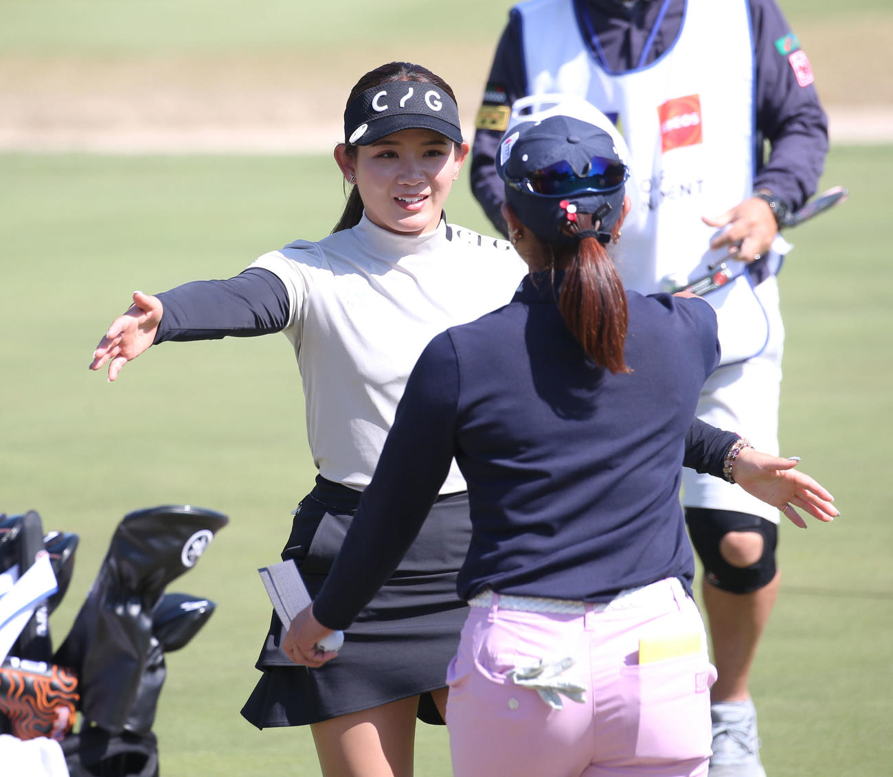 18番　ホールアウトし高木優（前方）と抱き合う吉本ひ（撮影・冨田成美）