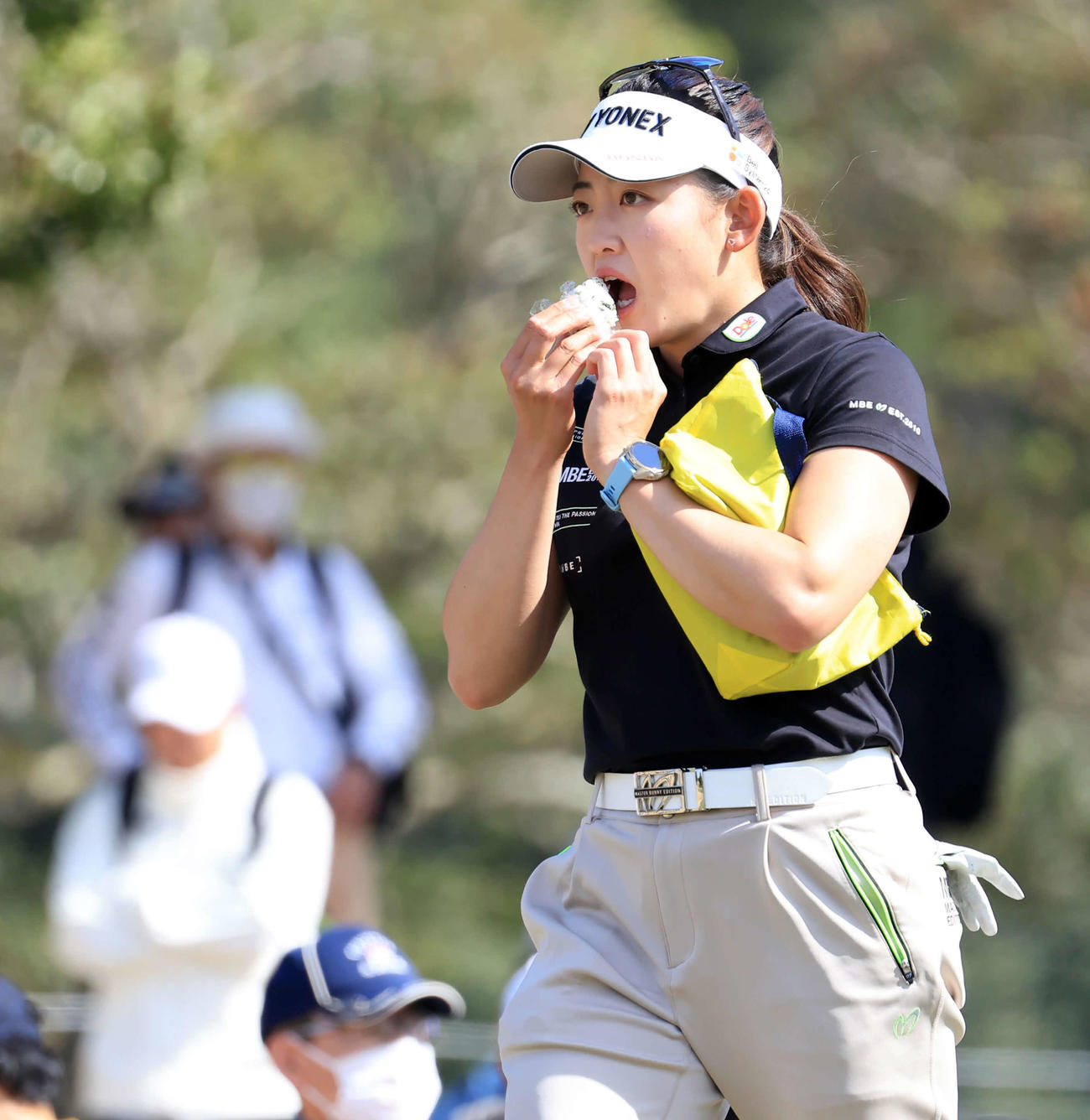 10番、ティーショット後、おにぎりをほおばる岩井千（撮影・浅見桂子）