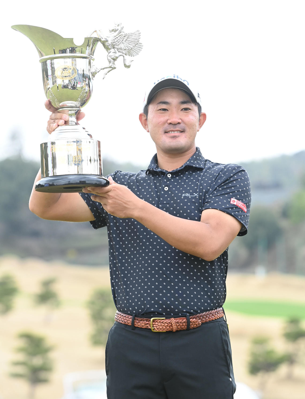 23アンダーで優勝しカップを掲げる金谷（撮影・和賀正仁）