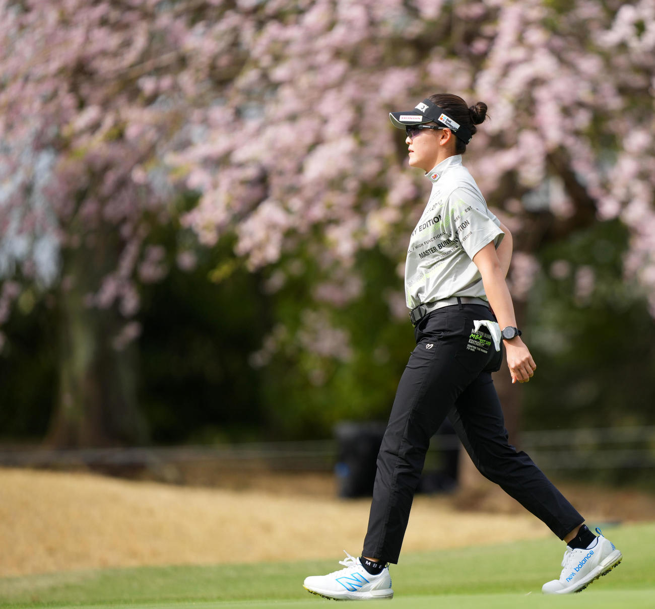 2番、桜の前を歩く岩井千怜（撮影・横山健太）