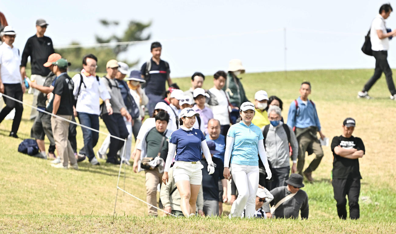 16番、ギャラリーを引き連れラウンドする小祝（手前左）と山内（撮影・滝沢徹郎）