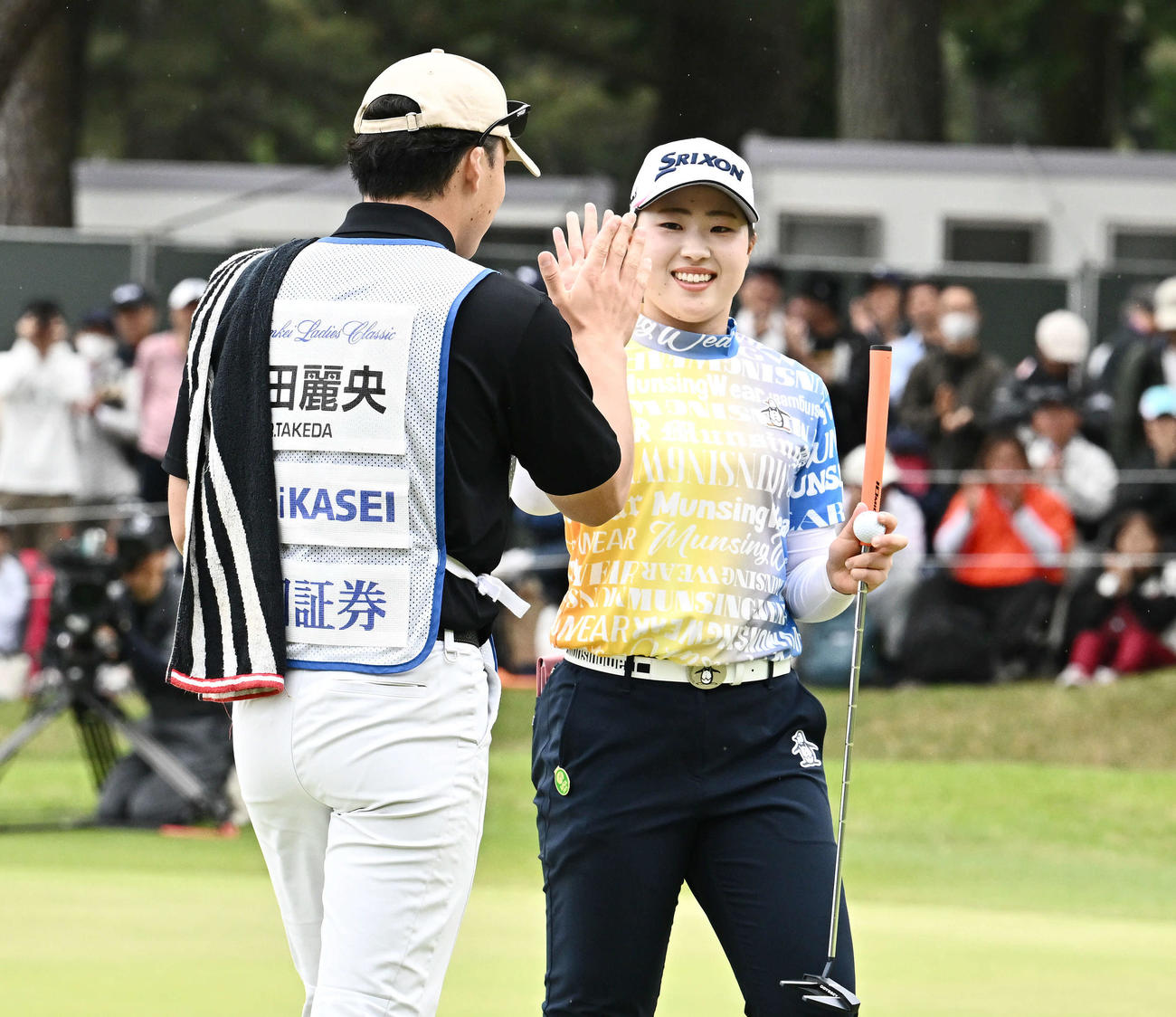 優勝を決めた竹田（右）はキャディーとタッチをかわす（撮影・滝沢徹郎）