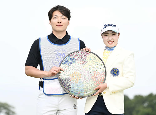 優勝トロフィーを手に記念撮影する竹田（右）とキャディーを務めた兄の有男さん（撮影・滝沢徹郎）