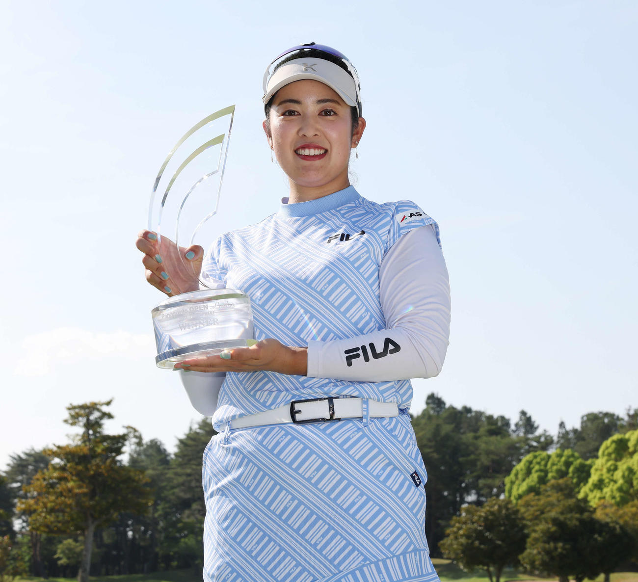 優勝トロフィーを手に笑顔の天本（撮影・宮地輝）
