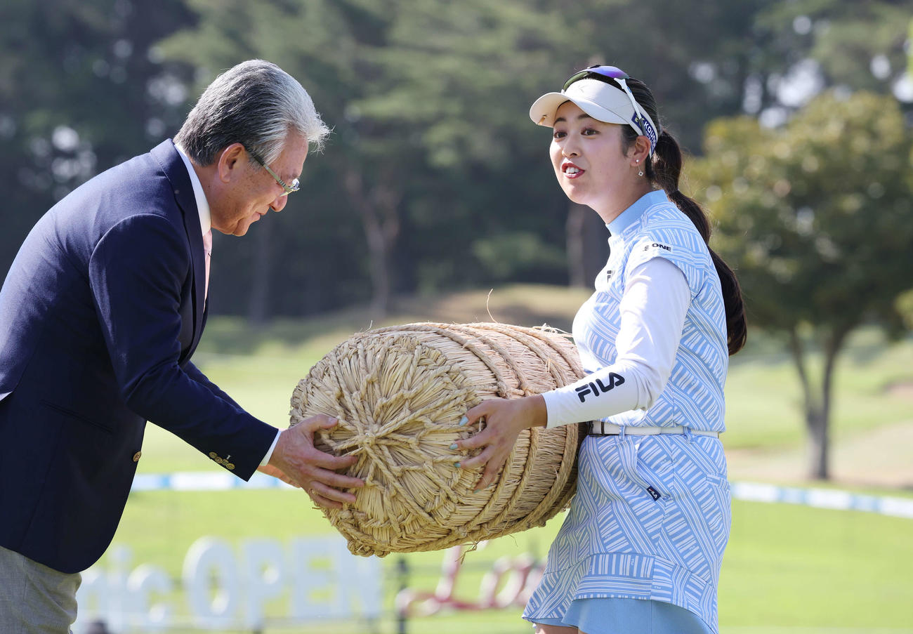 初優勝した天本は副賞の米俵を重そうに受け取る（撮影・宮地輝）