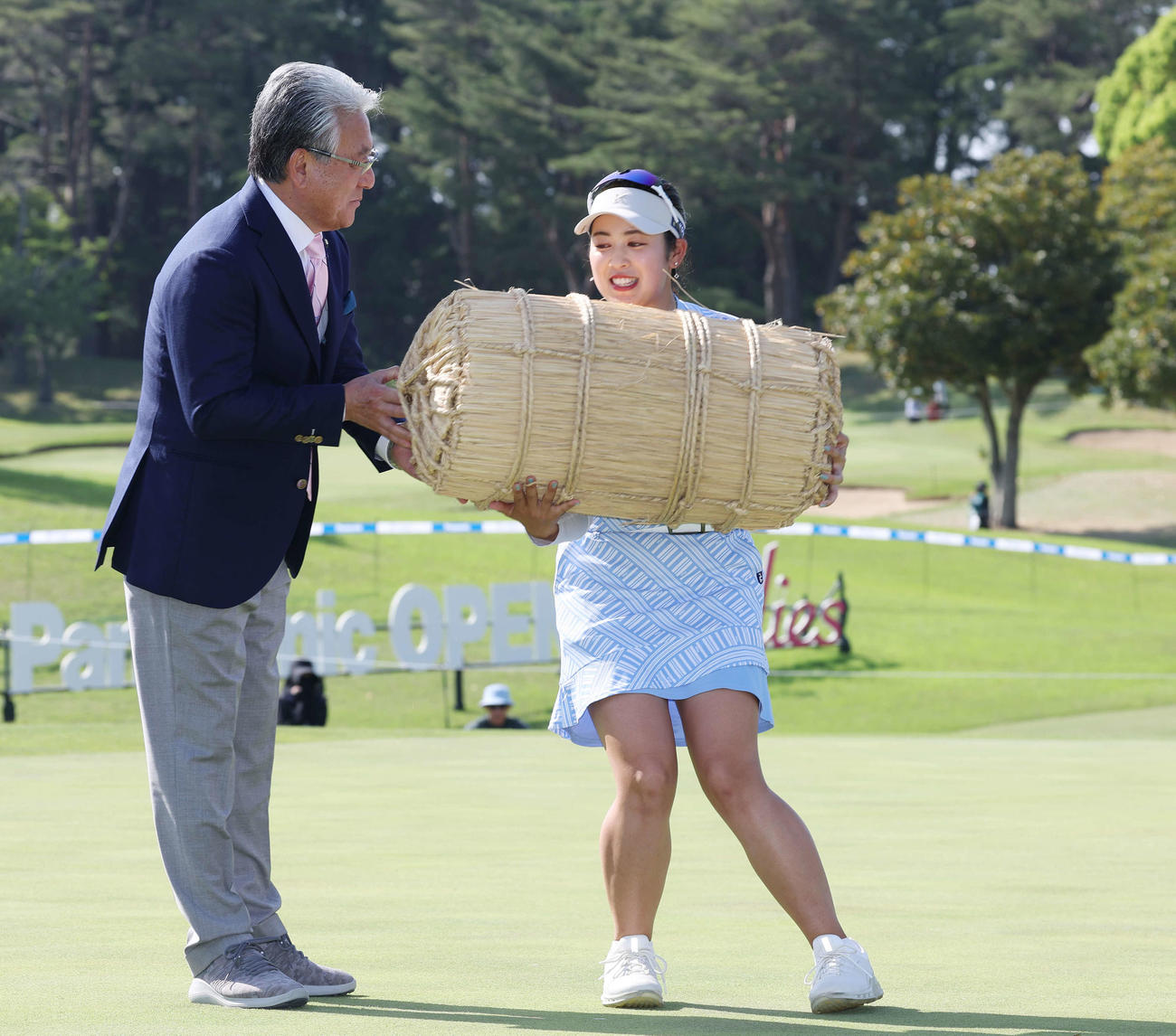 初優勝した天本は副賞の米俵を重そうに受け取る（撮影・宮地輝）
