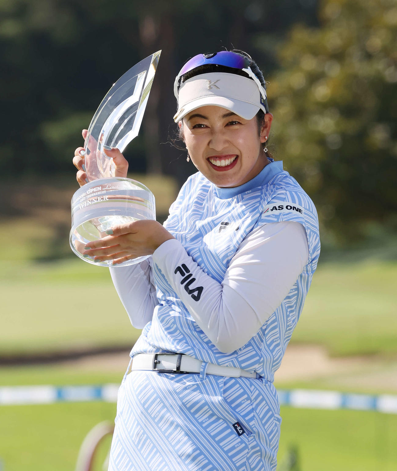 重たい優勝トロフィーを頑張って持つ天本（撮影・宮地輝）