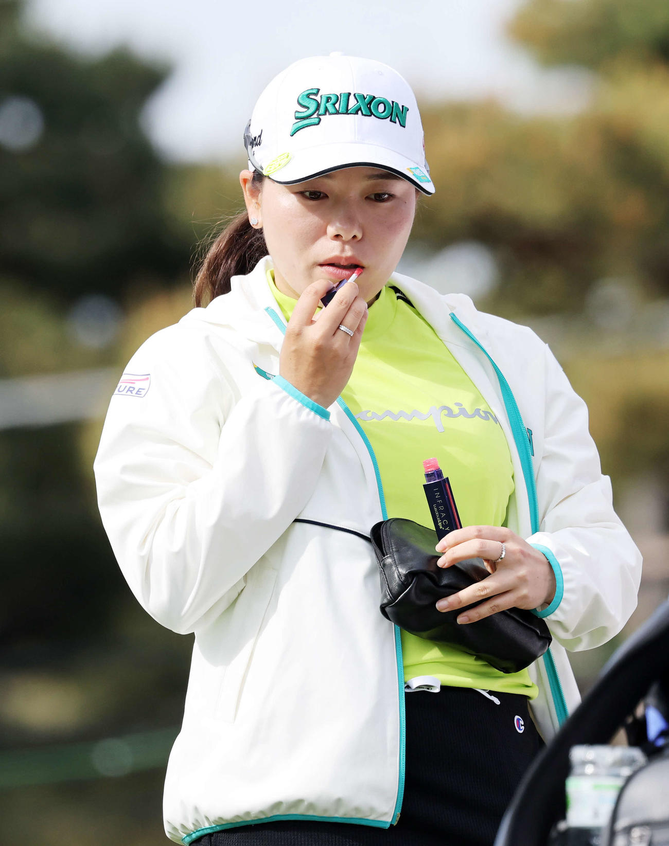 10番、ティーショット前、口紅をつける勝みなみ（撮影・鈴木正人）