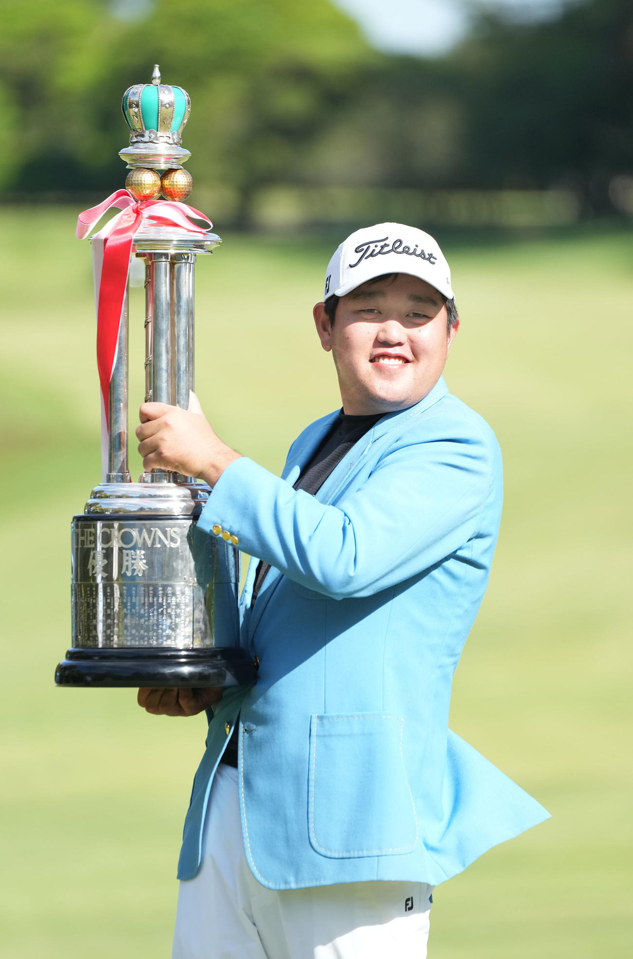 通算13アンダーでツアー初勝利しトロフィーを手に笑顔を見せる米沢（撮影・森本幸一）