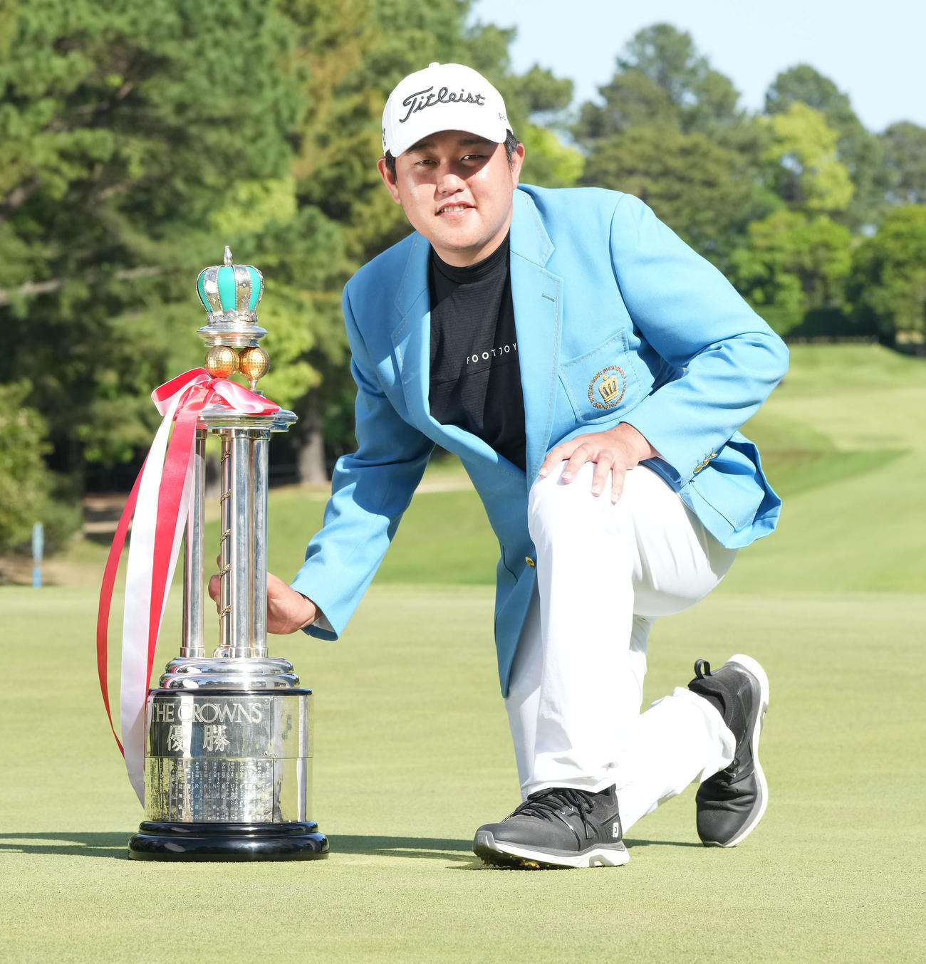通算13アンダーでツアー初勝利しトロフィーを手に笑顔を見せる米沢（撮影・森本幸一）