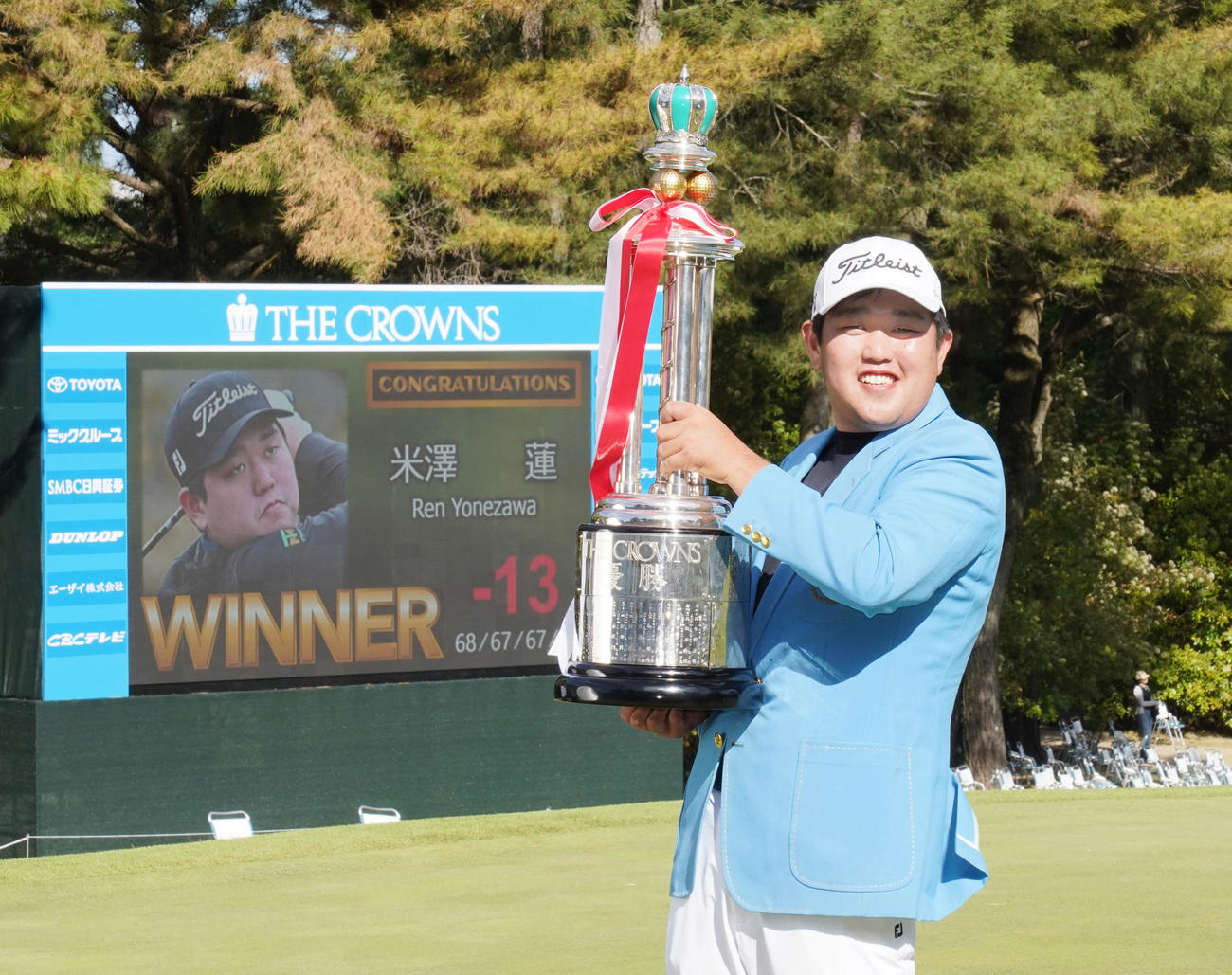 通算13アンダーでツアー初勝利しトロフィーを手に笑顔を見せる米沢（撮影・森本幸一）