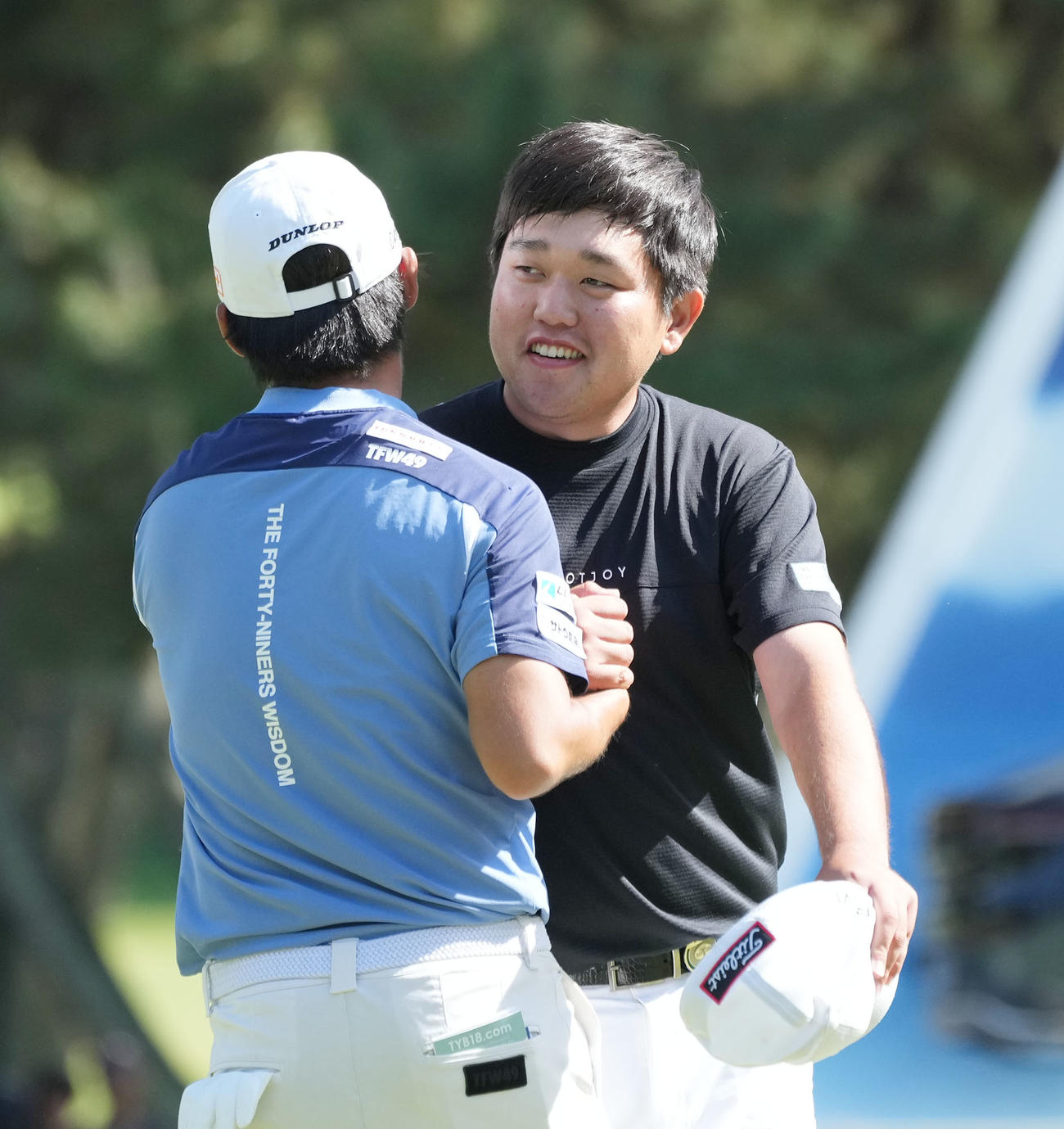 優勝争いをした同組の片岡尚と健闘をたたえ合う米沢（右）（撮影・森本幸一）