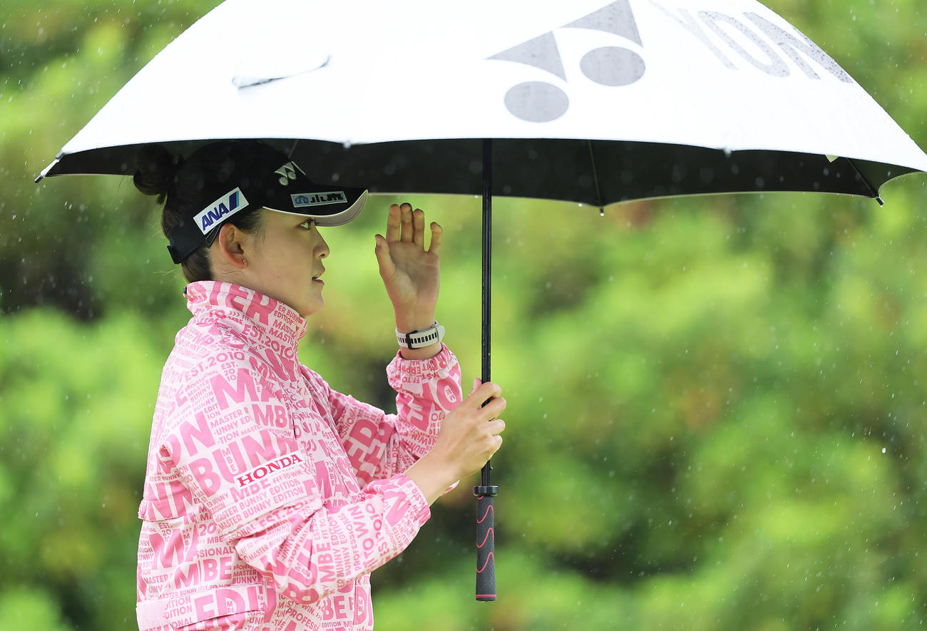 かさをさしながら移動する岩井千（撮影・足立雅史）