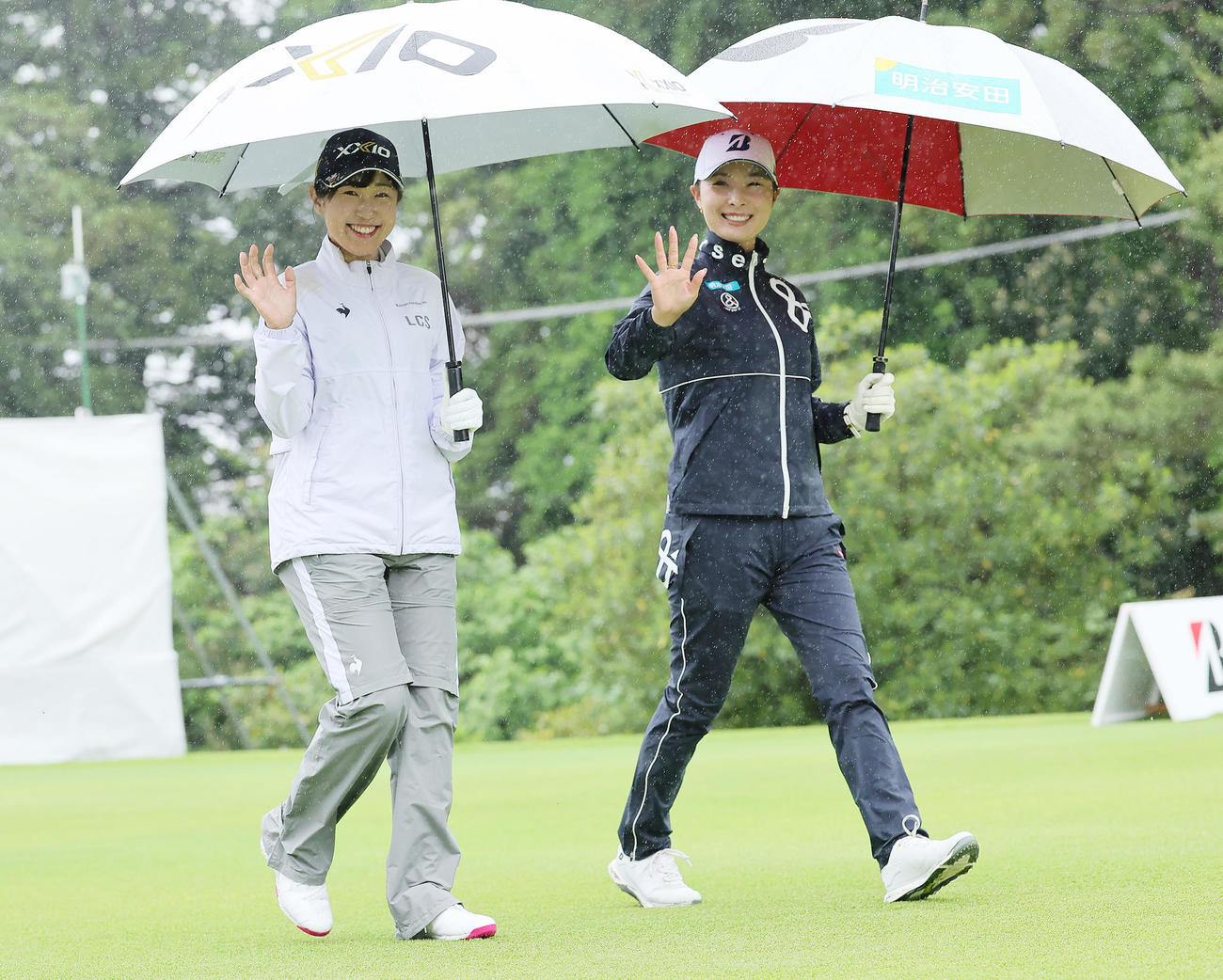 雨の中、笑顔で移動する菅沼（左）と鶴岡（撮影・足立雅史）
