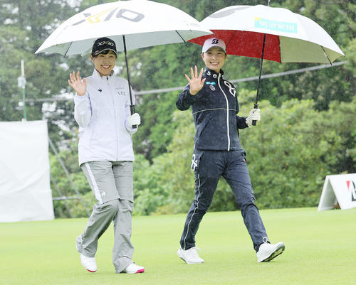 雨の中、笑顔で移動する菅沼（左）と鶴岡（撮影・足立雅史）