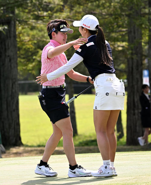 18番、通算15アンダーで優勝、金沢志奈（右）の祝福を受ける岩井明（撮影・前岡正明）