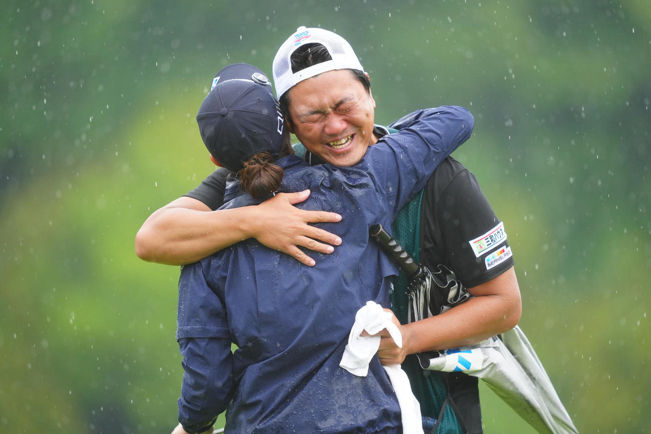 優勝を決めた新垣（左）と涙の抱擁を交わす兄でキャディーの夢蔵さん（撮影・垰建太）