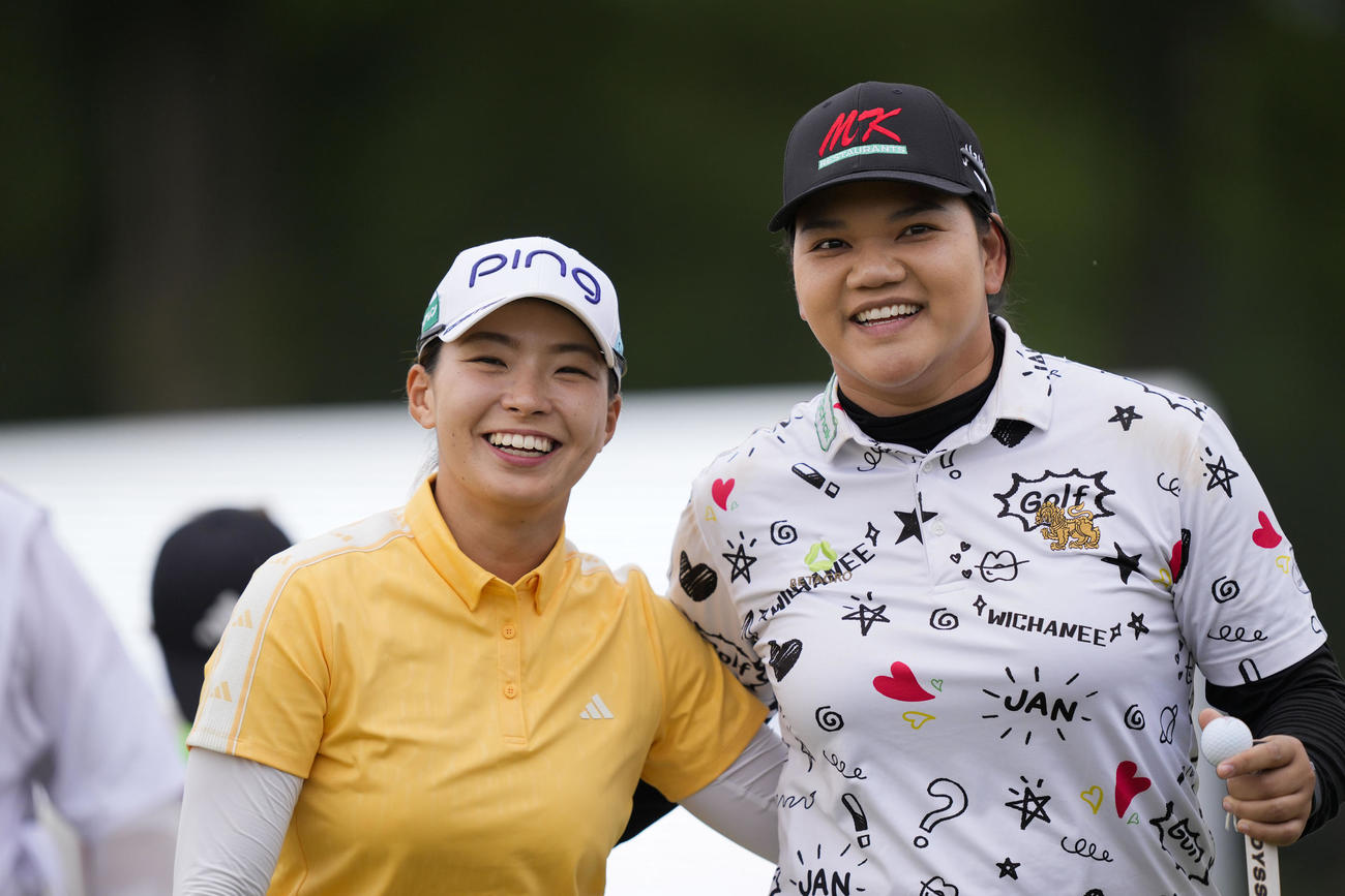 18番グリーンで肩を組む渋野日向子(左)とタイのウィチャニー・ミーチャイ(AP)
