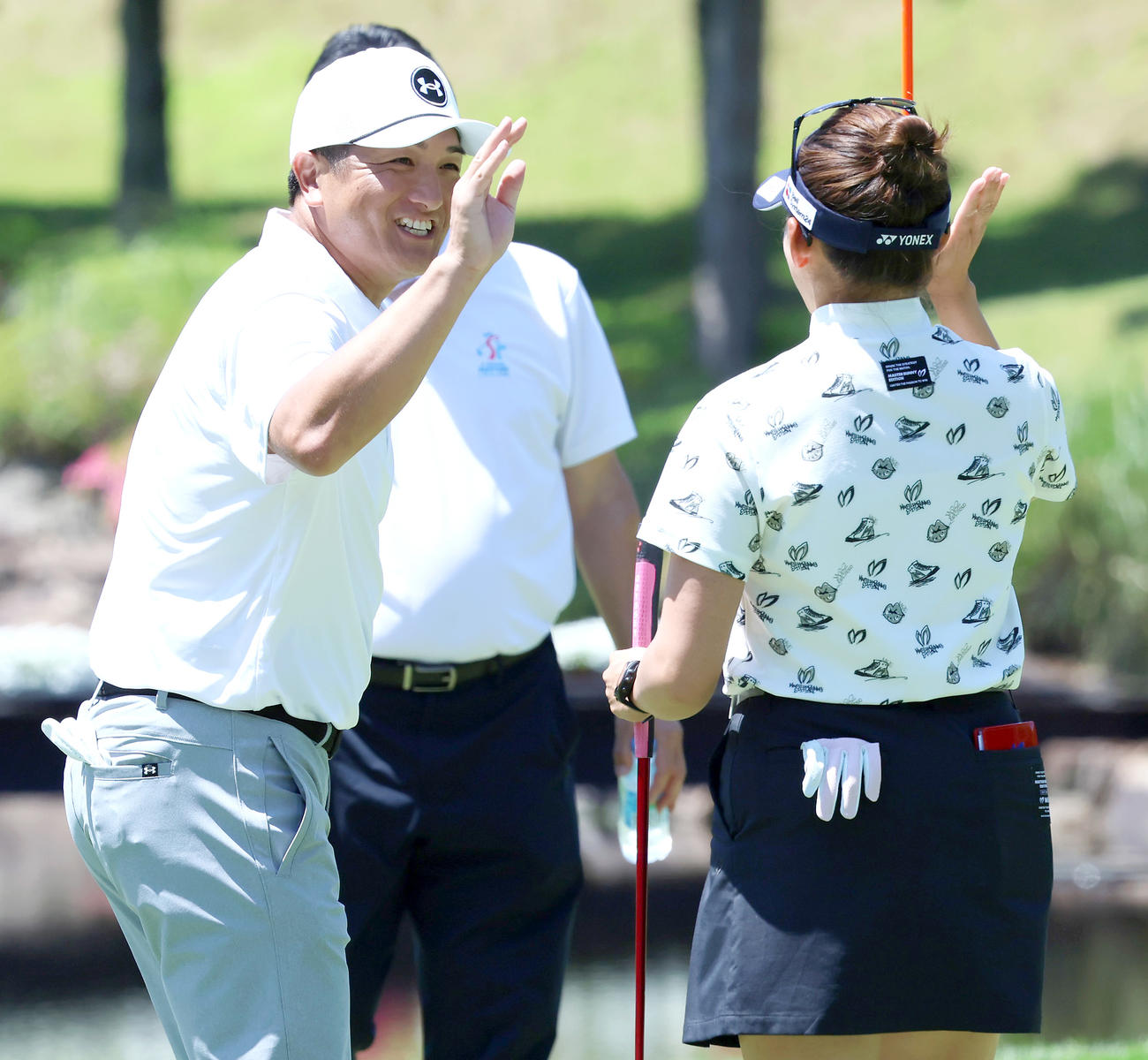プロアマ戦でホールアウトした高橋由伸氏は岩井千（手前）と笑顔でハイタッチする（撮影・上山淳一）