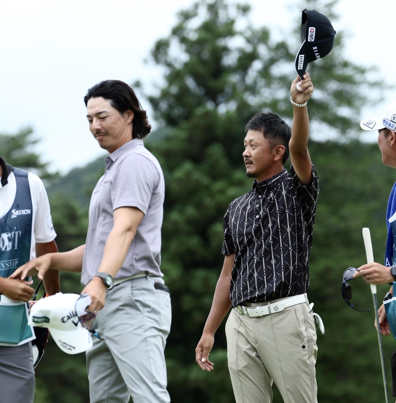 プレーオフを制し、ギャラリーの声援に応える岩田（右）。左は石川（撮影・河田真司）